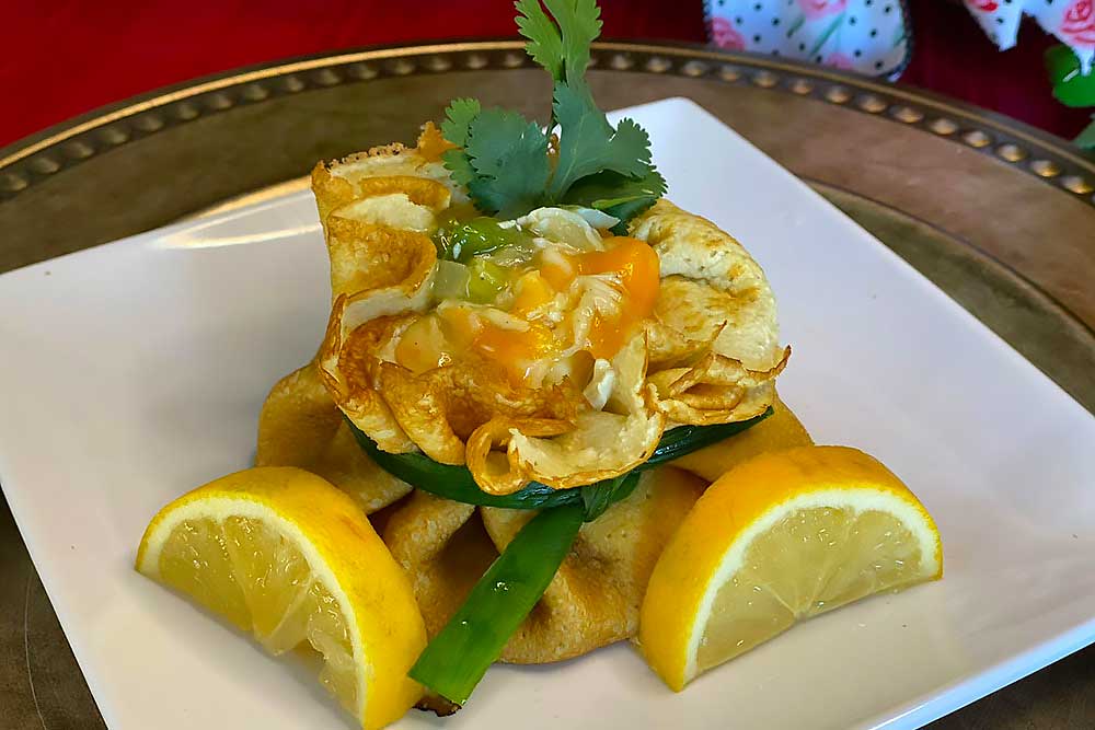A vibrant, allergen-friendly crepe filled with fresh produce, garnished with green herbs and lemon wedges, presented on a white plate. The dish emphasizes wholesome, natural ingredients, ideal for those seeking healthy living options.| Daré Vita Café | Las Vegas