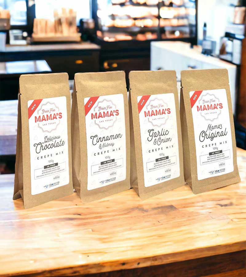 ingredients-image-home Four brown paper bags of crepe mix with various flavors are displayed on a wooden table in a café. The products emphasize allergen-friendly and gluten-free options, offering a nourishing choice for those with food sensitivities.| Daré Vita Café | Las Vegas