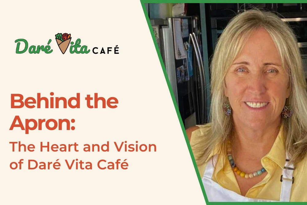 A smiling person in a yellow shirt and apron stands in a modern kitchen, representing Daré Vita Café, known for allergen-friendly, plant-based meals with fresh,…| Daré Vita Café | Las Vegas